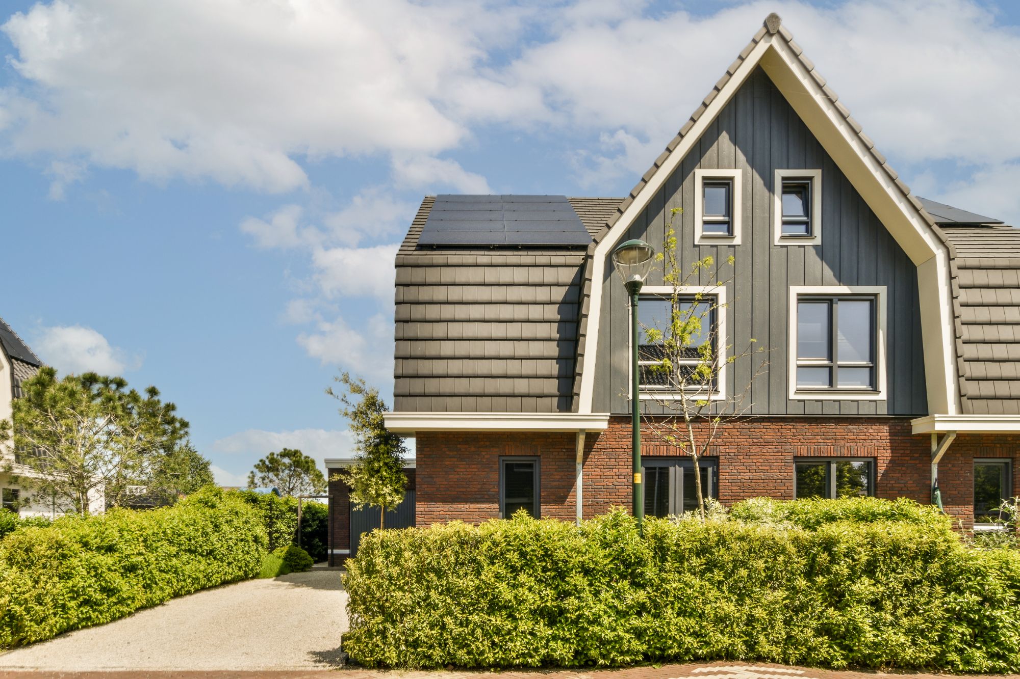 a-brick-house-with-a-grey-roof-and-a-driveway-BLSGHB6.jpg